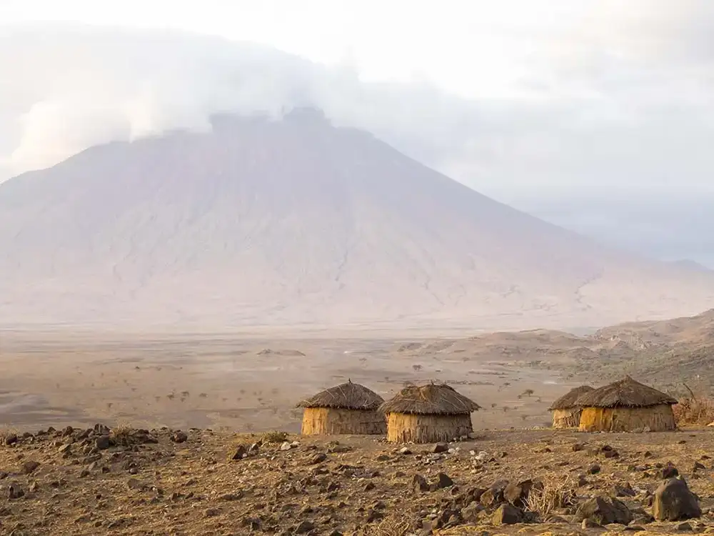 Volcano rising above huts on the plain